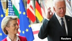 U.S. President Joe Biden crosses his fingers next to European Commission President Ursula von der Leyen as they attend the EU-US summit, in Brussels, Belgium June 15, 2021. REUTERS/Yves Herman