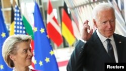 El presidente de EE. UU., Joe Biden, cruza los dedos junto a la la presidenta de la Comisión Europea, Ursula von der Leyen., durante la cumbre EE. UU.-UE en Bruselas el 15 de junio de 2021.