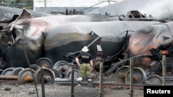 A police officer looks at the train wreckage in Lac-Megantic, July 9, 2013.