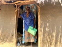 Rebecca Kara, 74, carries her personal documents to head to Swinga Health Centre 3 to get the AstraZeneca vaccine in Yumbe district, northern Uganda. (Halima Athumani/VOA)