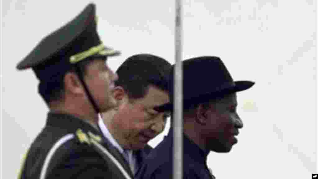 Chinese President Xi Jinping gestures to invite President Jonathan to review an honor guard during a welcome ceremony in Beijing.