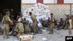 Tentara Turki dan pemberontak Suriah yang didukung Turki berkumpul dekat Kota Ras al-Ayn, dekat perbatasan Suriah, 12 Oktober 2019.