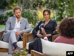 This undated image released March 7, 2021 courtesy of Harpo Productions shows Britain's Prince Harry (L) and his wife Meghan (C), Duchess of Sussex, in a conversation with US television host Oprah Winfrey. - Britain's royal family on March 7, 2021…