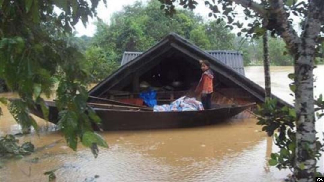 Seorang gadis kecil berdiri di sebuah perahu di tengah-tengah banjir di provinsi Ha Tinh, Vietnam.