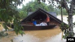 Seorang gadis kecil berdiri di sebuah perahu di tengah-tengah banjir di provinsi Ha Tinh, Vietnam.