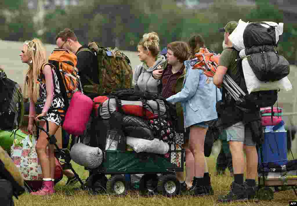 Revelers arrive to attend the Glastonbury Festival of Music and Performing Arts on Worthy Farm near the village of Pilton in Somerset, South West England.