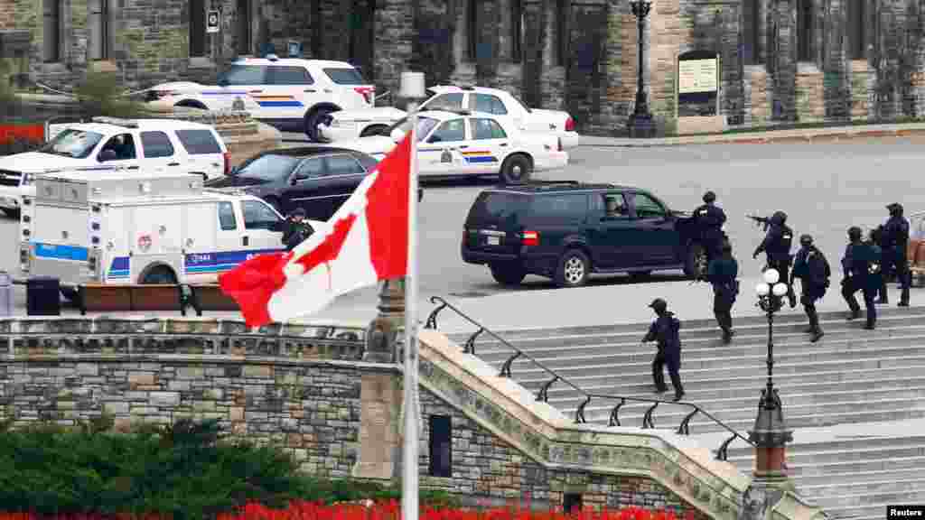 Des agents de la GRC, armés jusqu&#39;aux dents,&nbsp; lancent un assaut à l&#39;édifice du Parlement après une fusillade à Ottawa, le 22 Octobre 2014. 