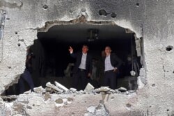 German Foreign Minister Heiko Maas, right, and Israeli Foreign Minister Gabi Ashkenazi visit the site of a rocket attack in the central Israeli city of Petah Tikvah, May 20, 2021.