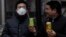 Chinese multimillionaire Chen Guangbiao (R) gives a can of fresh air to a man wearing a mask on a hazy day in central Beijing, January 30, 2013.