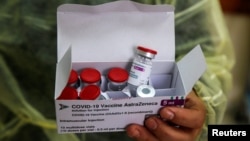 Seorang petugas medis di sebuah klinik di Jenin, Tepi Barat, membawa kotak berisi botol vaksin COVID-19 produksi AstraZeneca, 22 Maret 2021. 