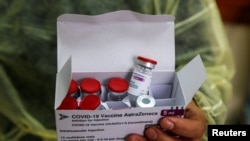 A health worker holds a box contains vials of AstraZeneca vaccine against the coronavirus disease (COVID-19) at a clinic in Jenin, in the Israeli-occupied West Bank, March 22, 2021.