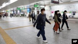 Para pengunjung berjalan di stasiun Yokohama, Prefektur Kanagawa, dekat Tokyo, 21 Mei 2020.