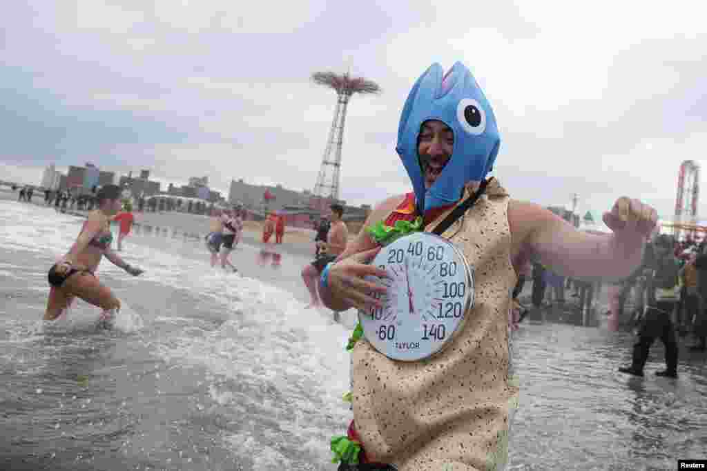 A costume wearing bather runs into the sea during the annual Polar Bear swim marking New Year&rsquo;s Day, at Coney Island, in New York City.