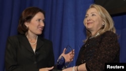 Ngoại trưởng Clinton trao cho chị gái Anne Stevens của cố đại sứ Hoa Kỳ Chris Stevens giải thưởng Common Ground nhằm vinh danh ông Stevens tại Viện Khoa học Carnegie, Washington, 8/11/2012. (REUTERS/Yuri Gripas)