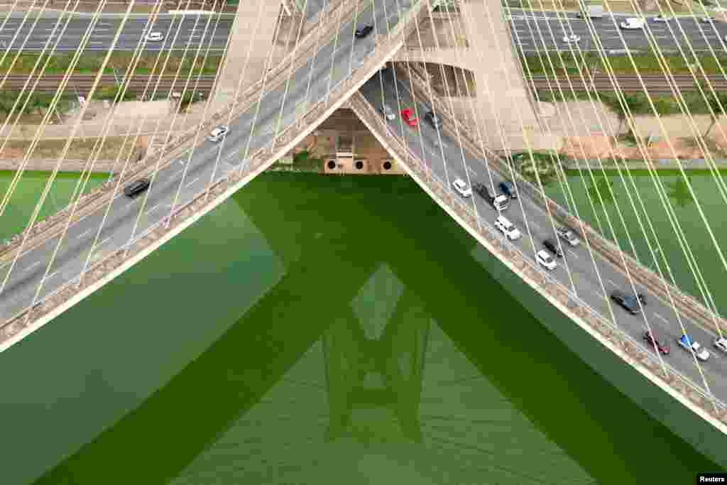 A drone view shows the Estaiada bridge reflected on algae proliferation turning the Pinheiros River green after dry weather and lack of rain reduced tributary contributions, increasing nutrient concentration and favoring algae growth, in Sao Paulo, Brazil, Sept. 10, 2024.