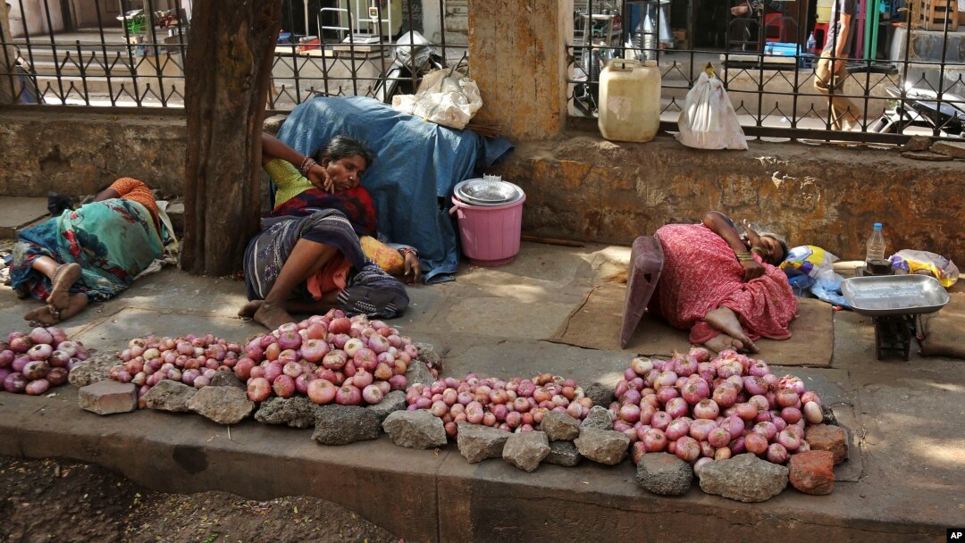 Ibu-ibu lansia pedagang bawang merah di Hyderabad, India tertidur kelelahan karena panasnya suhu udara di siang hari, Senin (25/5).