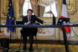 FILE - French President Emmanuel Macron conducts a phone call in his office at the Elysee Palace in Paris, France, on April 21, 2020.