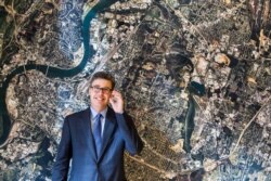 Chattanooga, Tenn., Mayor Andy Berke stands in front of an aerial image of Chattanooga, on the wall of his conference room, Nov. 17, 2014. Berke is a major promoter of the city's municipal fiber optic network