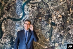 Chattanooga, Tenn., Mayor Andy Berke stands in front of an aerial image of Chattanooga, on the wall of his conference room, Nov. 17, 2014. Berke is a major promoter of the city's municipal fiber optic network