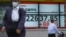 A man walks past an electronic stock board showing Japan's Nikkei 225 index at a securities firm in Tokyo, June 24, 2020. 