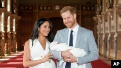 Pangeran Harry dan istrinya, Meghan, saat berfoto dengan putra mereka yang baru lahir di Kastil Windsor, 8 Mei 2019. (Foto: AP)