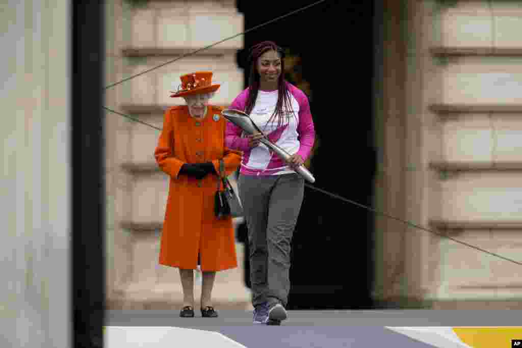 Baton bearer Kadeena Cox of Britain, who won two gold medals at the Rio 2016 Paralympic Games, receives&nbsp; from Queen Elizabeth II&nbsp;the baton&nbsp;to be used&nbsp;at the Birmingham 2022 Commonwealth Games Queen&#39;s Baton Relay event, outside Buckingham Palace in London.