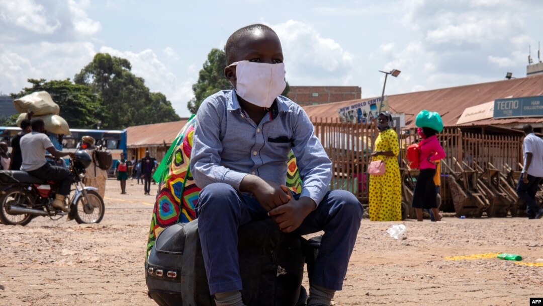 A boy sits on a bag at the old taxi park in Kampala, Uganda, on June 04, 2020, the first day of re-opening public transport.