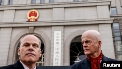 Los miembros de la embajada de Canadá ante China William "Bill" Klein y Jim Nickel frente a la corte de Beijing donde se juzga a puerta cerrada al exdiplomático canadiense Michael Kovrig por cargos de espionaje, el 22 de marzo de 2021.