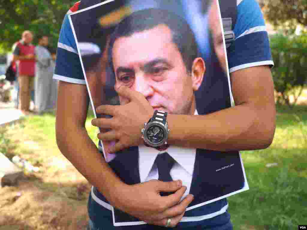 A man holds a Mubarak poster in front of Maadi Military hospital to share the celebration of the national day with Mubarak while he was hospitalized in 2015. (Photo: Hamada Elrasam / VOA) 