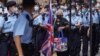 A man holds flowers to mourn the death of the assailant who stabbed a police officer in Hong Kong, July 2, 2021. 