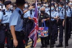A protester holding a U.K. flag is arrested by police officers during the 24th anniversary of Hong Kong handover to China at a street in Hong Kong, July 1, 2021.
