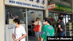 Orang-orang mengantri untuk menanyakan vaksin Sinovac di sebuah klinik, selama wabah COVID-19 di Singapura, 18 Juni 2021. (Foto: REUTERS/Chen Lin)