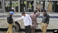 Security officials collect evidence at the site of a bomb blast in Karachi, April 28, 2011.