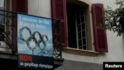 Poster yang berisi protes pencalonan tuan rumah Olimpiade Musim Dingin 2026 menjelang pemungutan suara di Kota Sion, Swiss, 6 Juni 2018.