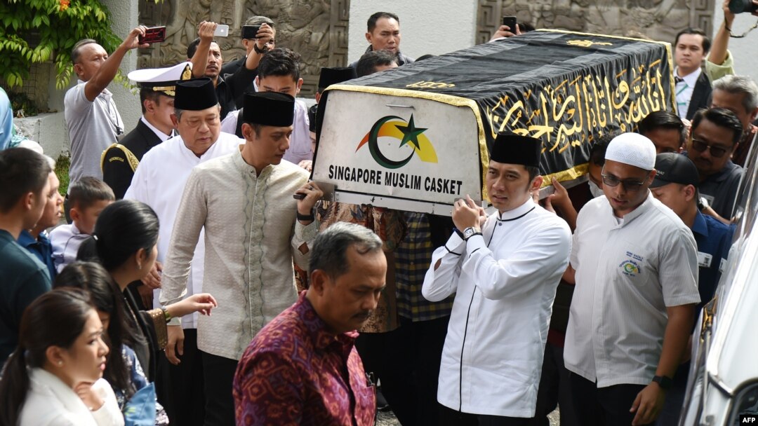 Mantan presiden RI Susilo Bambang Yudhoyono (kiri) berjalan di samping peti jenazah istrinya, Ibu Ani Yudhoyono, yang wafat di Singapura, Sabtu, 1 Juni 2019. (Foto: Roslan Rahman/AFP)