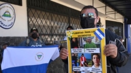 Un activista sostiene un cartel con un mensaje que lee: “Liberen a los sacerdotes” e imágenes del clero encarcelado por el gobierno de Daniel Ortega, durante una protesta frente a la embajada de Nicaragua, en San José, Costa Rica, el 20 de febrero de 2023