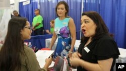 Roxy Creed (L) speaks to Mandara Spa Operations Manager Lena Andrade about employment opportunities at a job fair in Honolulu, Hawaii, March 28, 2018.