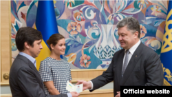 Prezident Petro Poroshenko (o'ngda) Vladimir Fedorin va Mariya Gaydarga Ukraina pasportini topshirmoqda, Kiyev, 4-avgust, 2015-yil.