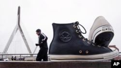 Classic "Chuck Taylor" sneakers are positioned outside the world headquarters of Converse, Inc. as a runner passes in Boston, Dec. 29, 2016.