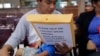 Immigrants from Guatemala seeking asylum look over travel packets as they wait at the bus station after they were processed and released by U.S. Customs and Border Protection, June 21, 2018, in McAllen, Texas. 