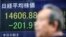 A man walks by an electronic stock price indicator showing the regional heavyweight, Tokyo's Nikkei 225, in Tokyo, April 8, 2014.