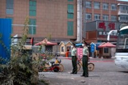 Paramilitary police stand guard near the Xinfadi wholesale food market district in Beijing, June 13, 2020. Beijing closed the market after the discovery of at least six more coronavirus cases.