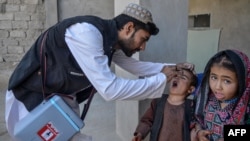 An Afghan health worker administers polio vaccine drops to a child during a polio vaccination campaign in Kandahar, Afghanistan, Jan. 27, 2025.