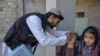 An Afghan health worker administers polio vaccine drops to a child during a polio vaccination campaign in Kandahar on January 27, 2025.
