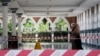 A woman wearing a protective mask walks at a mosque following the outbreak of coronavirus, in Kuala Lumpur, Malaysia, March 16, 2020. 