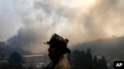 La silueta de un bombero se recorta contra un cielo lleno de humo mientras un incendio forestal se propaga hacia Viña del Mar, Chile, el sábado 3 de febrero de 2024.