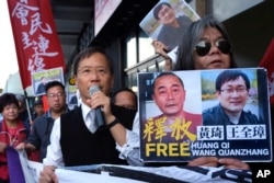 FILE - In this Jan. 29, 2019, file photo, protesters demonstrate outside China's Liaison Office in Hong Kong in support of prominent Chinese human rights lawyer Wang Quanzhang (right of poster).