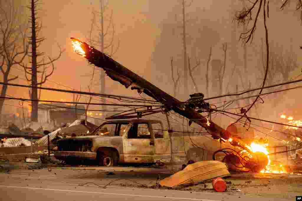 A utility pole burns and comes crashing down as the Dixie Fire tears through the Greenville community of Plumas County, California, Aug. 4, 2021.