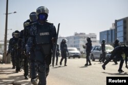 FILE - Gendarmes walk as they clash with Senegalese demonstrators during a protest against the postponement of the Feb. 25 presidential election, in Dakar, Senegal February 4, 2024.