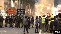 Polisi Hong Kong menembakkan gas air mata ke arah demonstran pro-demokrasi pada aksi demonstrasi hari Minggu (29/9). 